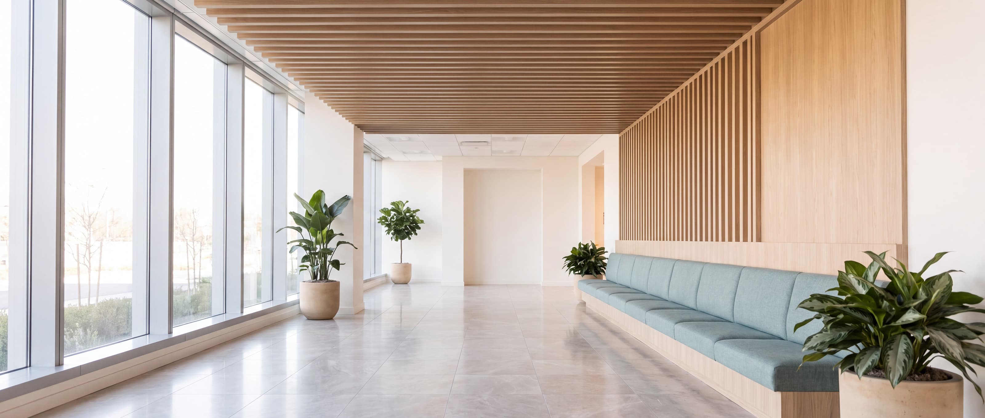 A serene, sunlit clinic waiting lounge with oak panels and teal seating
