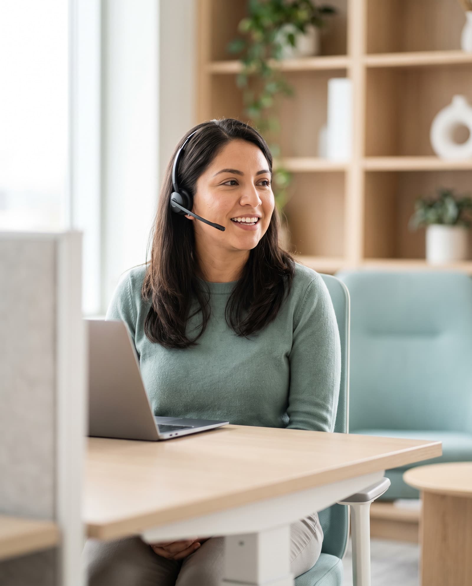 A patient support specialist wearing a headset, mid-conversation